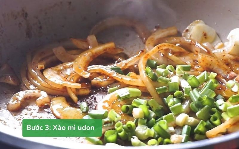 Xào thơm tỏi, hành tây, thêm sốt, hành lá và mì udon