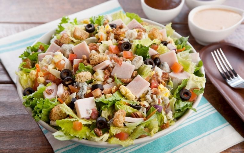 Salad combines greens, fruits, and dressing, for a fresh and nutritious flavor