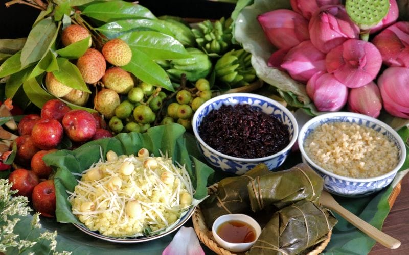 The offering tray for the 5th day of the 5th lunar month in the Northern region includes com ruou nep cai hoa vang, ruou nep cam, and banh tro