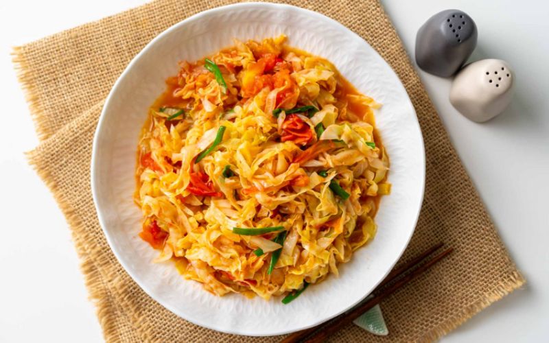 Appetizing stir-fried cabbage with tomatoes in harmonious red and yellow hues