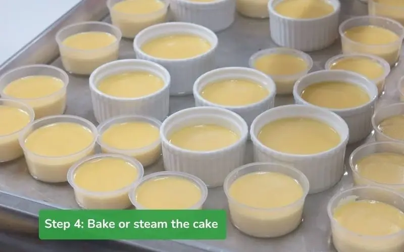 The flan molds are placed in a tray of water or steamed, ready for baking or steaming