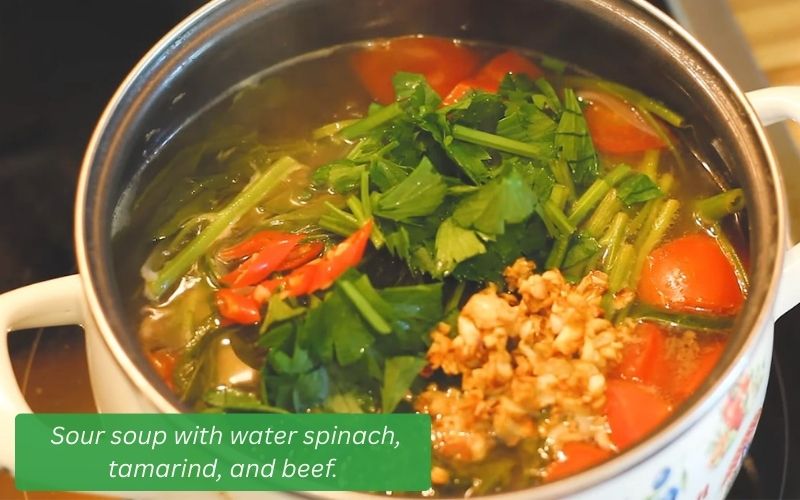 Finished sour soup with water spinach, tamarind, and beef.