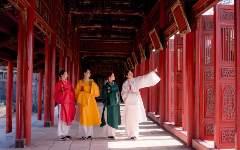 Chụp ảnh áo dài Tết tại bảo tàng trong không gian trưng bày truyền thống, tạo dáng tự nhiên, tôn nét dịu dàng.