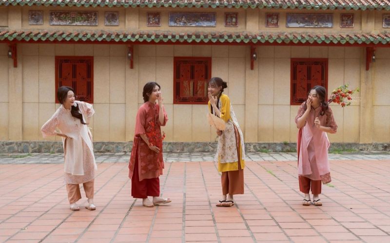 Nhóm bạn đứng cùng nhau chụp ảnh áo dài Tết, ghi lại khoảnh khắc thân thiết và ấm áp ngày xuân