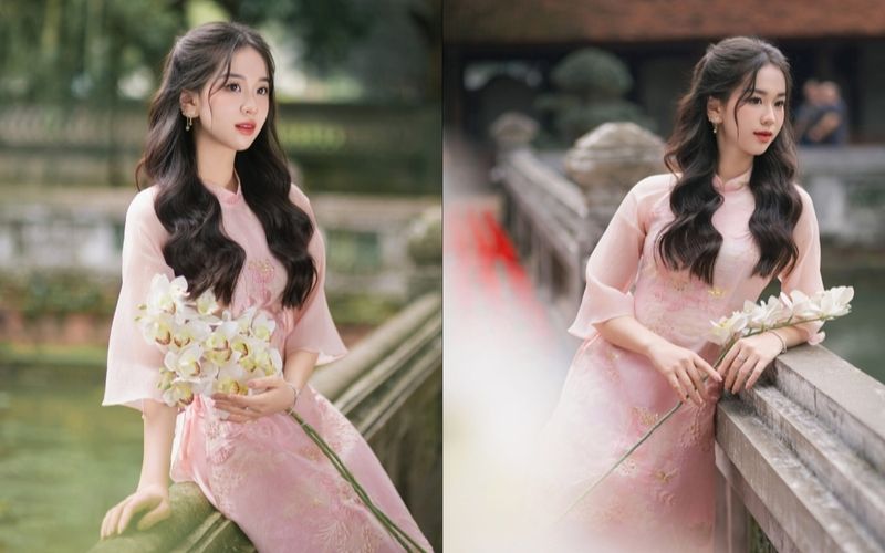 A girl wearing a traditional Vietnamese dress for Tet (Lunar New Year) holds a bouquet of flowers in her arms, smiling gently.