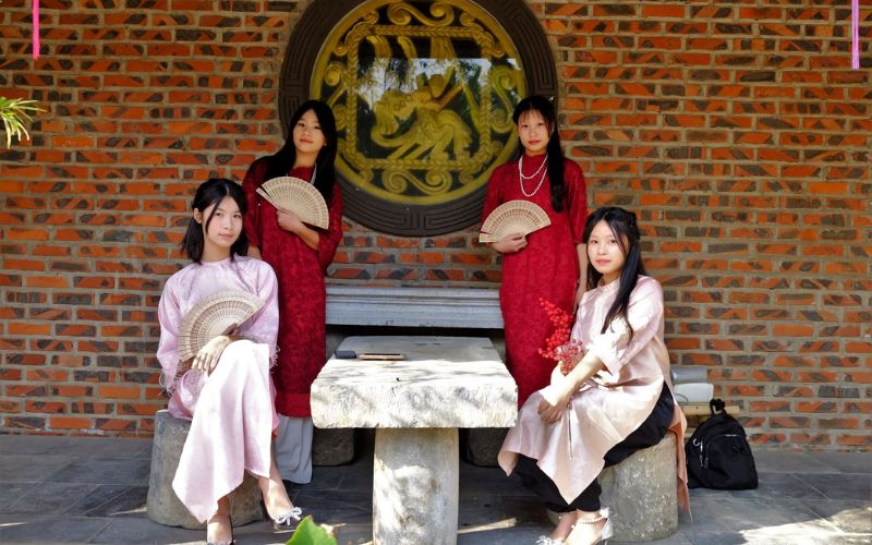 Posing for Tet (Vietnamese New Year) photos in a temple setting with a sacred atmosphere and elegant traditional attire.