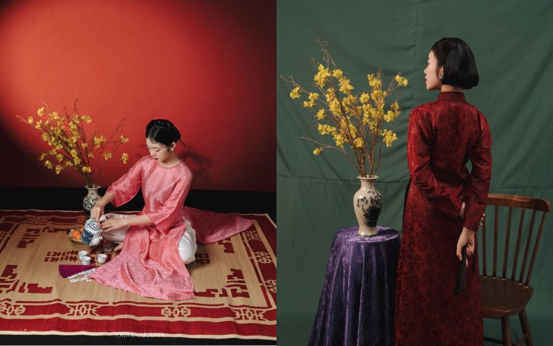 Wearing a traditional Vietnamese dress for Tet (Lunar New Year) and posing next to a branch of vibrant yellow apricot blossoms.