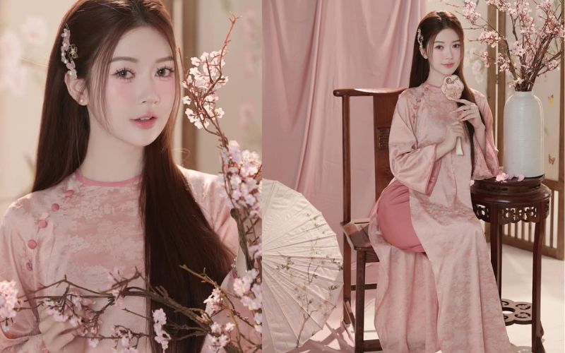 A girl wearing a traditional Vietnamese dress stands beside a branch of pink peach blossoms during Tet.