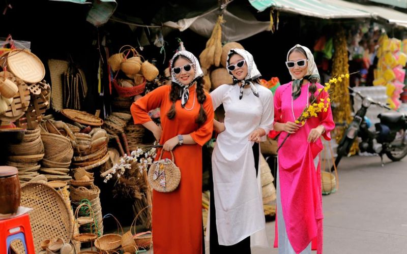 Posing for Tet (Lunar New Year) photos in traditional Ao Dai with friends, featuring a vintage concept.